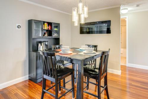 a dining room with a black table and chairs at 1 Mi to Millyard District Unit with Furnished Porch in Manchester
