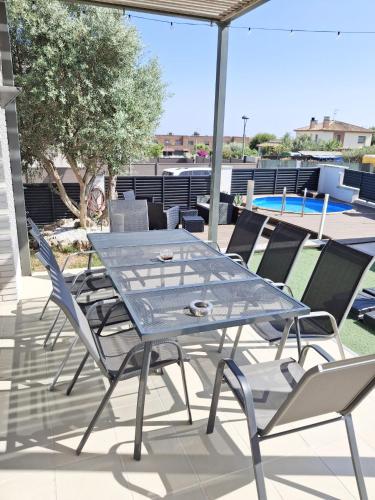 a glass table and chairs on a patio at Villa Serenità by Prolocal in Cunit