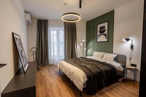 a bedroom with a bed and a green wall at Vidalis Suites in Cluj-Napoca