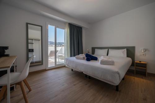 a bedroom with a bed and a desk and a window at Hotel Calella by Beatriz Hoteles in Calella