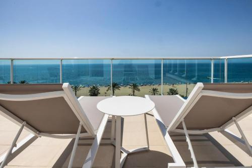 a balcony with a white table and two chairs at Hotel Calella by Beatriz Hoteles in Calella