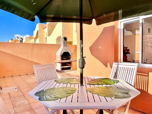 un tavolo con un ombrellone in un patio di Casa del Gato a Caleta De Fuste