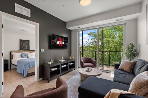 a living room with a couch and a bed and a tv at W315 Modern Luxury 1Bd Condo In Downtown Minneapolis, Minutes From Minneapolis Convention Center & US Bank Arena in Minneapolis
