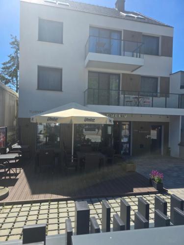 a building with a patio with an umbrella in front of it at M&K - Vyspa Apartamenty in Gdańsk