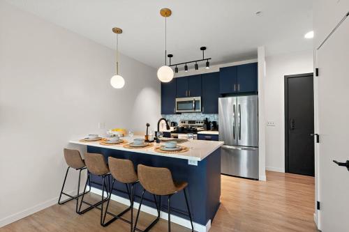 a kitchen with blue cabinets and a large island with bar chairs at W315 Modern Luxury 1Bd Condo In Downtown Minneapolis, Minutes From Minneapolis Convention Center & US Bank Arena in Minneapolis