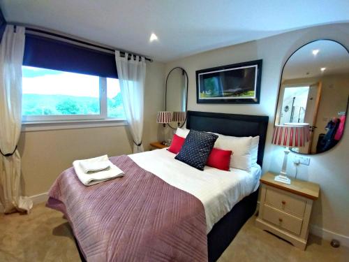 a bedroom with a large bed with a large window at Aber Holiday Rentals in Inverness