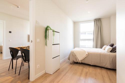 a bedroom with a bed and a desk and a table at Bext Valdebebas in Madrid