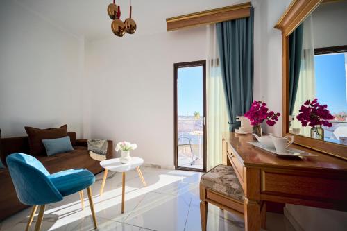 a living room with a blue chair and a table at EVLOGIA HOTEL SEAFRONT and ANEX by Greek Pride in Fourka
