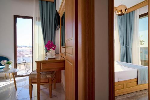 a bedroom with a desk and a bed and a table at EVLOGIA HOTEL SEAFRONT and ANEX by Greek Pride in Fourka