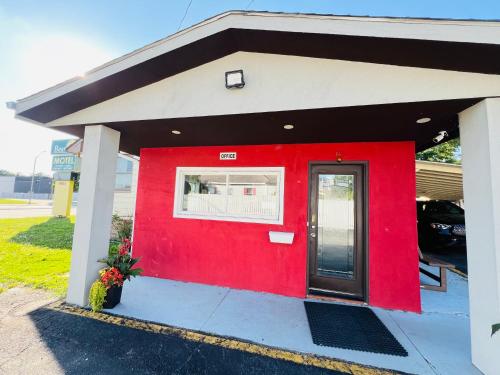 a red building with a red door at Bestway Motel in Windsor
