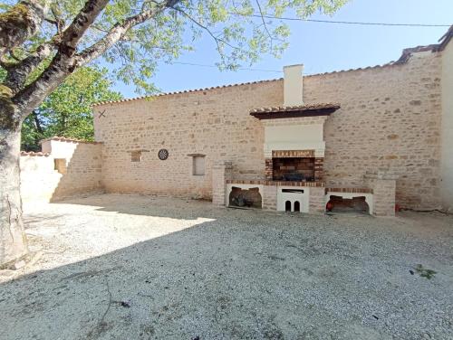 a brick building with a fireplace in front of it at Au Petit Bonheur de Lorigné in Lorigné