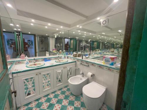 a bathroom with two sinks and a toilet and mirrors at EXCLUSIVE LUXURY HOUSE "VILLA POMPEIANA" IN VIA CAMERELLE 65a CON TERRAZZA VISTA MARE in Capri