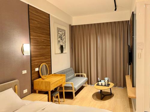 a hotel room with a bed and a desk at Choozme in Lugang