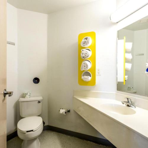 a bathroom with a toilet and a sink and a mirror at Motel 6-Roswell, NM in Roswell
