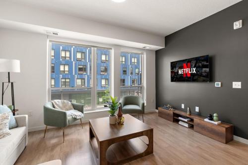 a living room with a couch and a tv on a wall at W208 Luxury Spacious 2Bd Condo In DT Minneapolis, Minutes From Minneapolis Convention Center & US Bank Arena in Minneapolis