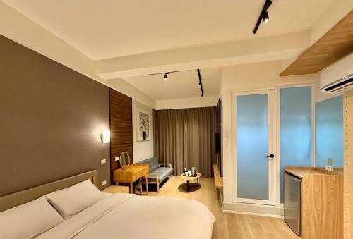 a hotel room with a bed and a chair at Choozme in Lugang