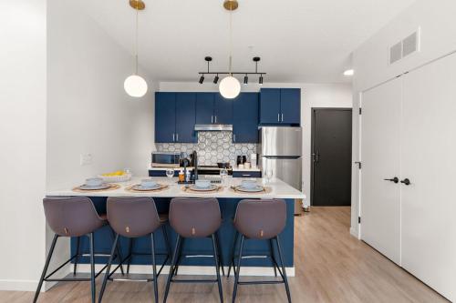 a kitchen with blue cabinets and a kitchen island with chairs at W208 Luxury Spacious 2Bd Condo In DT Minneapolis, Minutes From Minneapolis Convention Center & US Bank Arena in Minneapolis