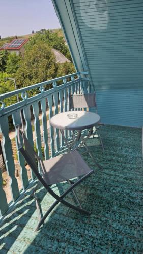 a table and a chair on a balcony at Bagaméri Vendégház in Badacsonytomaj