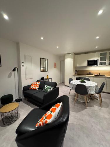 un salon avec un canapé noir et une table dans l'établissement La Petite Maison, à Villars