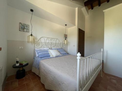 a bedroom with a white bed with blue sheets at Villa Kima tartufo in Toscella