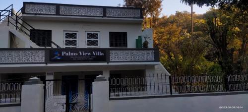 a white building with a sign on it at Palms View Villa in Mount Ābu