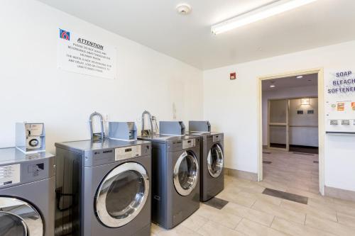 a laundry room with three washing machines in it at Motel 6-Roswell, NM in Roswell