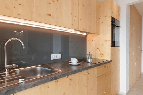 a kitchen with a stainless steel sink and wooden cabinets at Prielerhof in Chienes