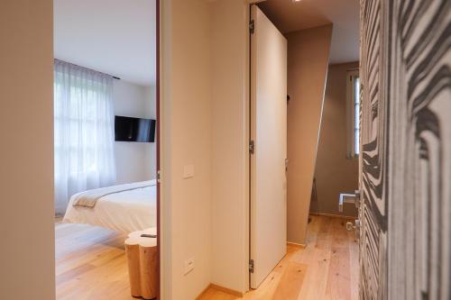a bedroom with a bed and a door leading into a room at Villa Amelia in Orta San Giulio