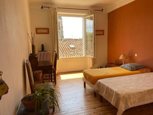 une chambre avec deux lits et une fenêtre dans l'établissement La chambre Terra Cotta, à La Celle-sous-Gouzon