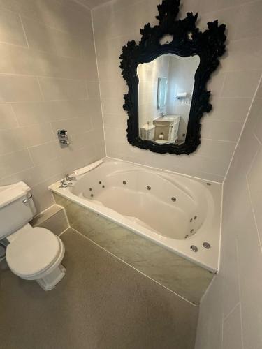 a bathroom with a tub and a toilet and a mirror at White Star Line Hotel in Liverpool