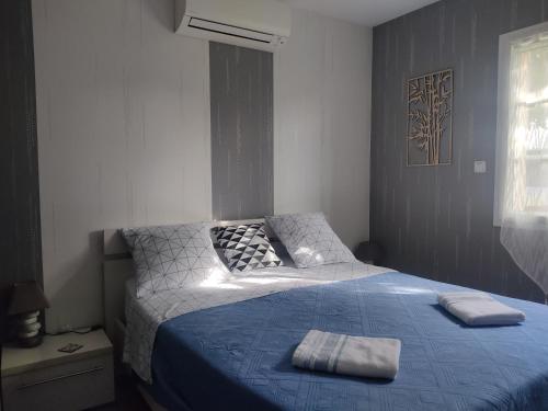 a bedroom with a bed with two towels on it at A la bonne étape in Sassenay