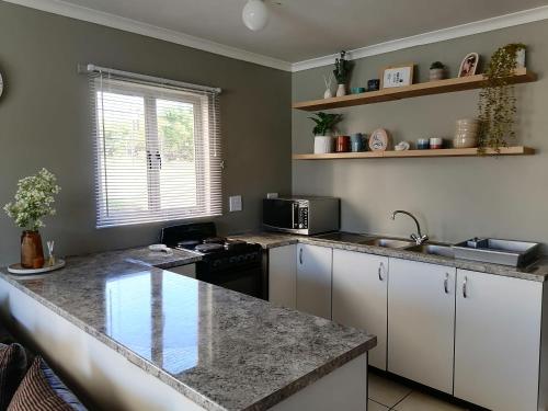 - une cuisine avec un plan de travail en granit et un évier dans l'établissement 46 at Mtwalume Holiday Resort, à Umtwalumi