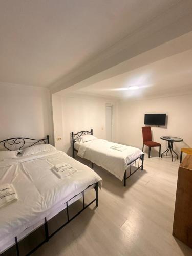 a room with two beds and a table with a chair at villa gardens in K'obulet'i