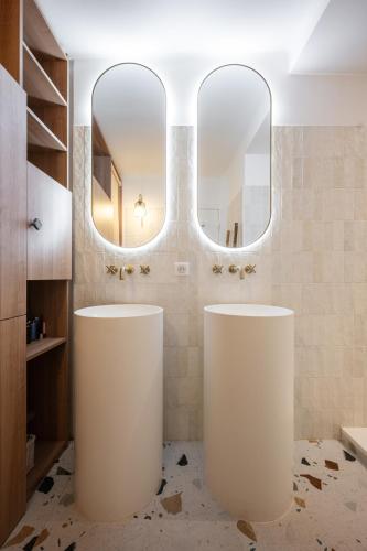 a bathroom with two large mirrors and two sinks at Soleil d'Or in Cagnes-sur-Mer