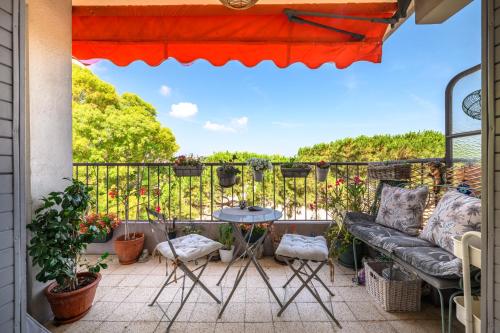 a patio with a couch and a table on a balcony at Soleil d'Or in Cagnes-sur-Mer