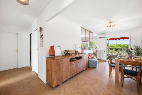 a kitchen with a wooden cabinet and a dining room at Soleil d'Or in Cagnes-sur-Mer