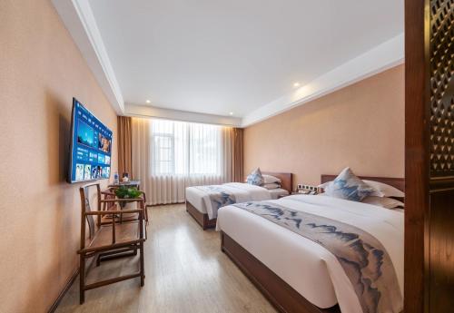 a hotel room with two beds and a tv at Mare Nubium Resort in Zhangjiajie