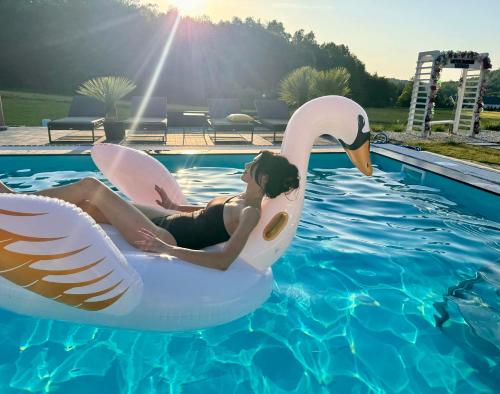 a woman is riding a swan in a pool at Bieszczadzka Wataha in Paszowa