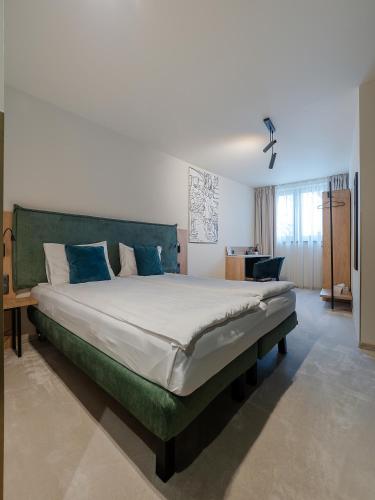 a bedroom with a large bed with blue pillows at Craft Inn - Boutique Hotel in Sibiu