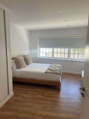 a bedroom with a bed and a large window at Amadeo Art&Stay Apartments in Amarante