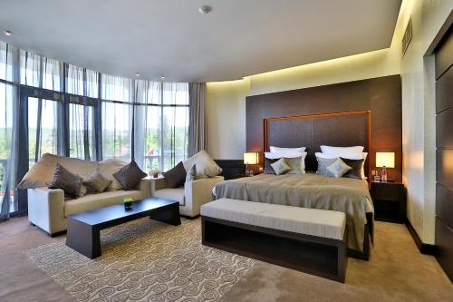una camera d'albergo con letto e divano di Donatello Boutique Hotel a Almaty