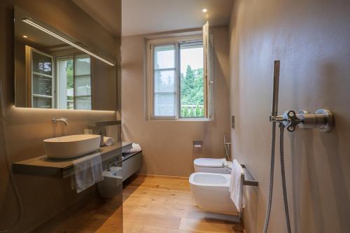 a bathroom with a sink and a toilet and a window at Villa Amelia in Orta San Giulio