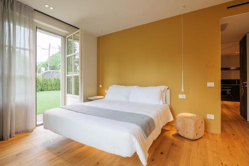 a bedroom with a large bed and a large window at Villa Amelia in Orta San Giulio