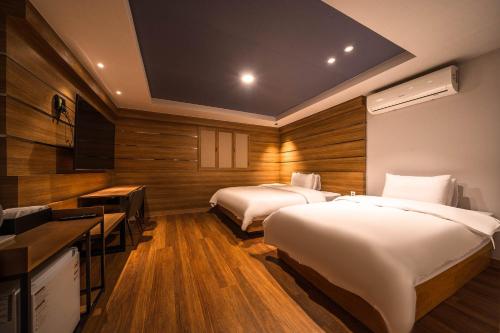 a hotel room with two beds and a television at Hotel New Castle Bupyeong in Incheon