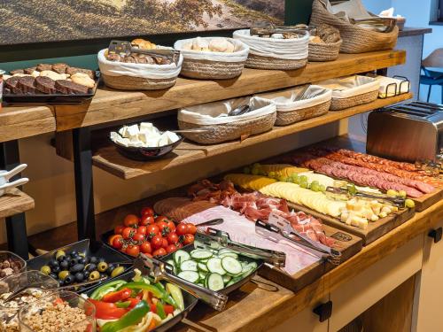 a buffet with many different types of vegetables and meats at Craft Inn - Boutique Hotel in Sibiu