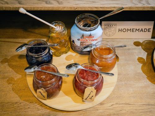 a plate of food with jars of jam and honey at Craft Inn - Boutique Hotel in Sibiu