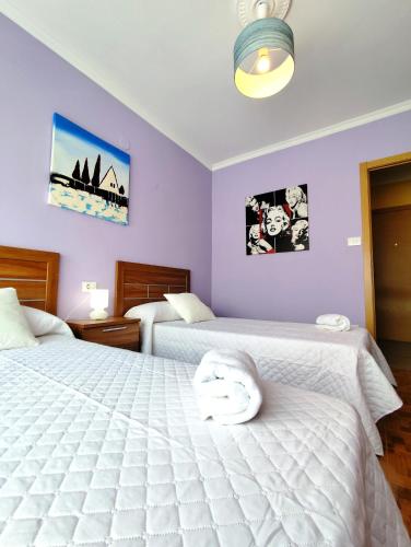 two beds in a bedroom with purple walls at Airtegal Litoral 49 Cedeira in Cedeira