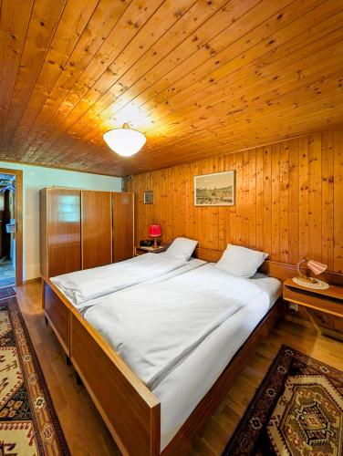 a large bed in a room with a wooden ceiling at Havre de paix aux Diablerets - chalet privé in Les Diablerets