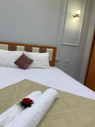 a bed with two towels and two roses on it at Garden City Hotel Nile Palace in Cairo