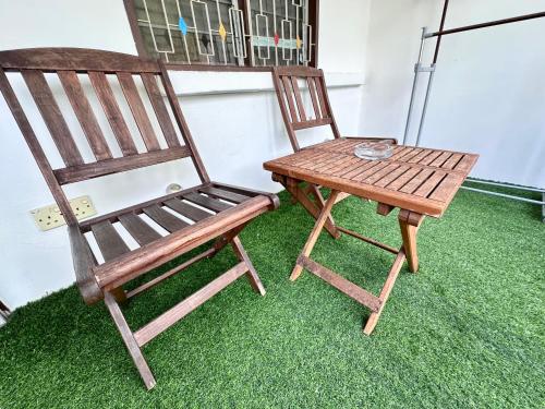 a wooden chair and a table on the grass at 26 Rangoon Residence 26 in George Town